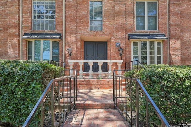 view of exterior entry with brick siding