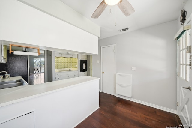 kitchen with ceiling fan, oven, hardwood / wood-style floors, sink, and kitchen peninsula