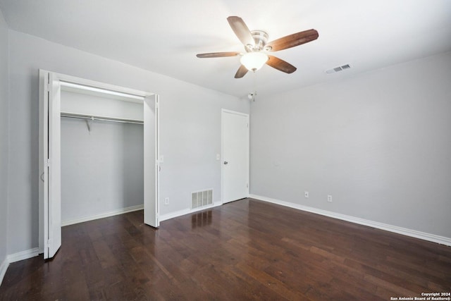 unfurnished bedroom with a ceiling fan, dark wood-style flooring, visible vents, and baseboards