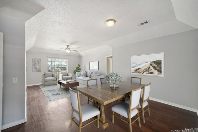 dining room featuring dark wood-style floors, visible vents, a textured ceiling, and baseboards