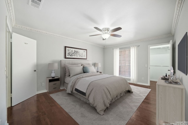 bedroom with crown molding, visible vents, dark wood finished floors, and baseboards