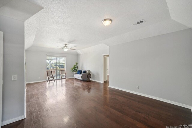 unfurnished room featuring dark wood-style floors, a textured ceiling, visible vents, and baseboards