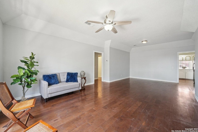 sitting room featuring ceiling fan, baseboards, and dark wood finished floors