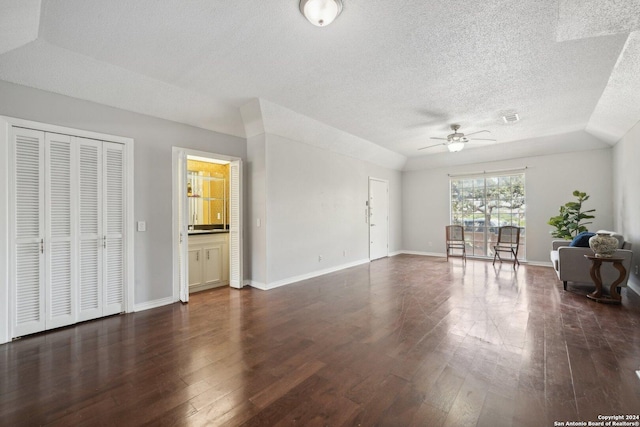 unfurnished living room with a textured ceiling, visible vents, baseboards, a ceiling fan, and dark wood finished floors