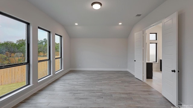 empty room featuring lofted ceiling and light hardwood / wood-style floors