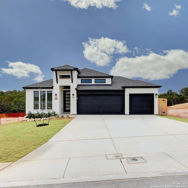 prairie-style house with a garage and a front lawn