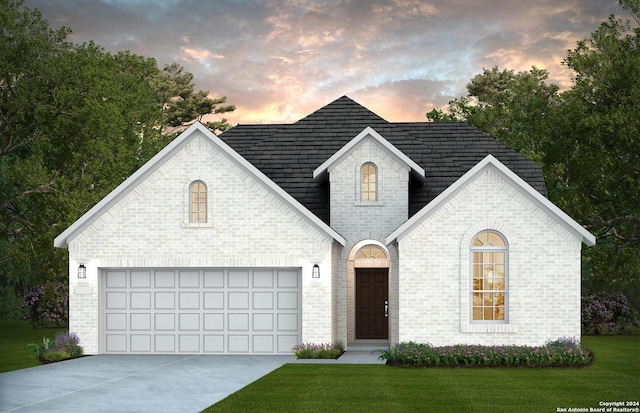 view of front facade featuring an attached garage, a yard, concrete driveway, and brick siding