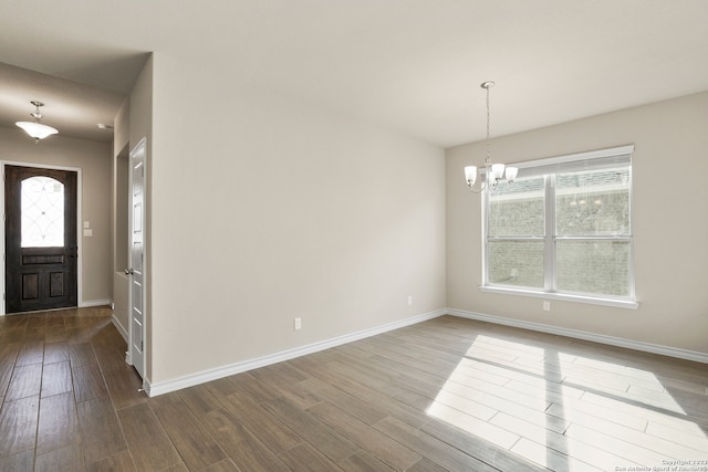 foyer with hardwood / wood-style flooring, an inviting chandelier, and a healthy amount of sunlight