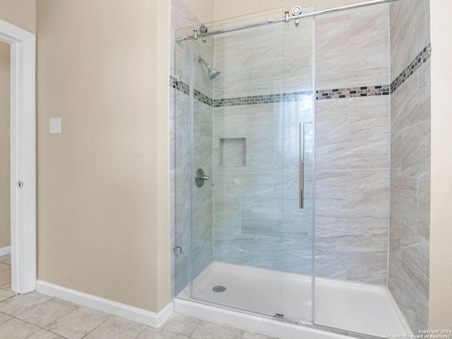 bathroom featuring an enclosed shower and tile patterned floors