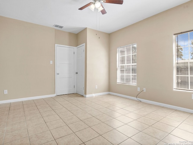 empty room featuring light tile patterned flooring and ceiling fan