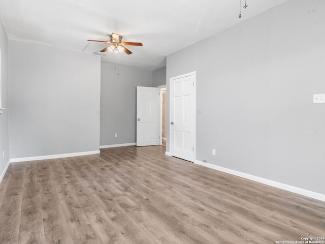 empty room with ceiling fan and light hardwood / wood-style floors