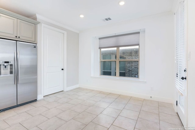 kitchen with ornamental molding, stainless steel built in fridge, and light tile patterned floors