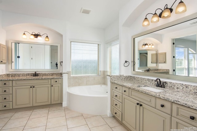 bathroom with tile patterned flooring, vanity, plenty of natural light, and a bathing tub