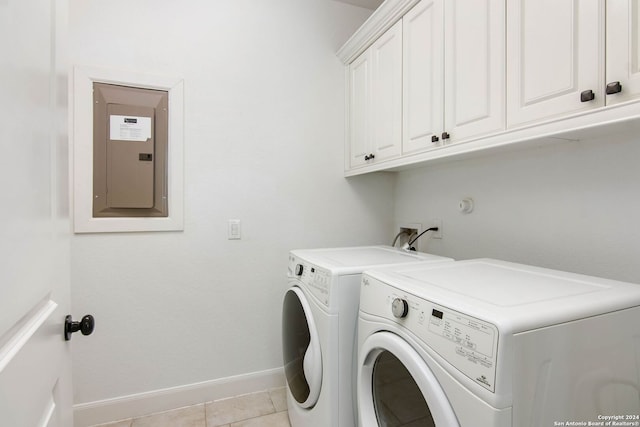 laundry room with cabinets, electric panel, washing machine and dryer, and light tile patterned floors