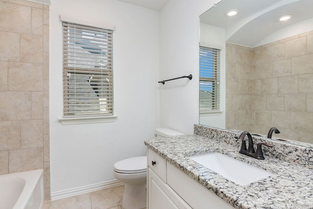 bathroom featuring vanity, plenty of natural light, tile patterned floors, and toilet