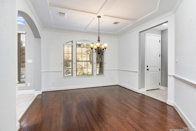 unfurnished dining area with hardwood / wood-style flooring, coffered ceiling, a wealth of natural light, and an inviting chandelier