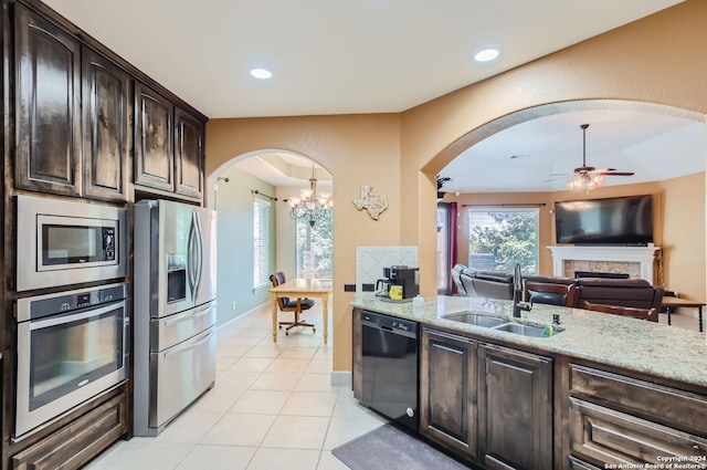 kitchen featuring dark brown cabinetry, light stone counters, sink, and stainless steel appliances