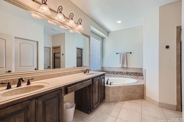 bathroom featuring tiled bath, tile patterned flooring, and vanity