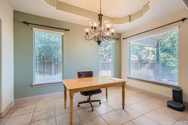 tiled office space with a notable chandelier and a tray ceiling