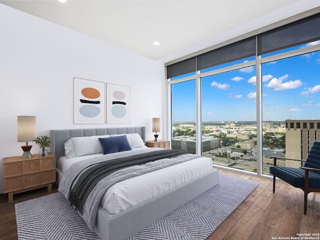 bedroom featuring hardwood / wood-style floors, expansive windows, and access to exterior