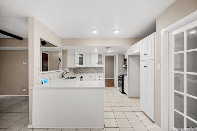 kitchen with white cabinetry, sink, backsplash, kitchen peninsula, and appliances with stainless steel finishes