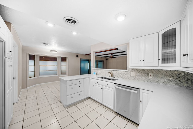 kitchen featuring kitchen peninsula, tasteful backsplash, stainless steel dishwasher, sink, and white cabinets