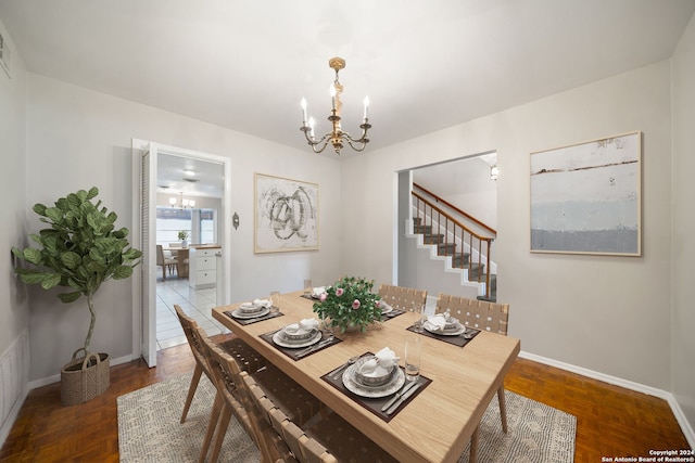 dining room featuring dark parquet floors and an inviting chandelier