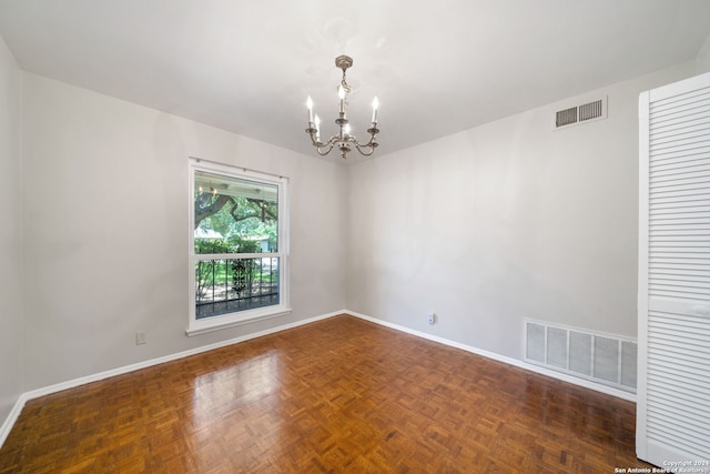 empty room with dark parquet flooring and an inviting chandelier