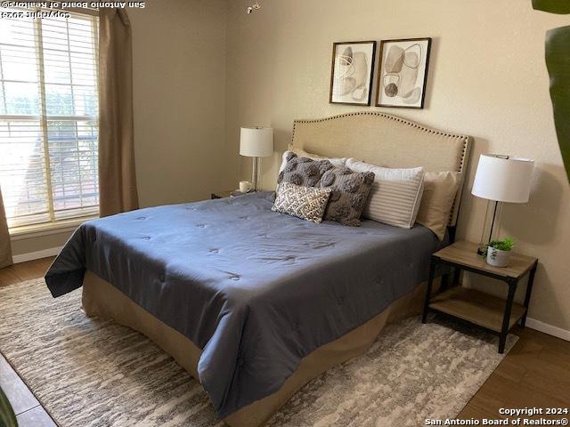 bedroom featuring baseboards and wood finished floors