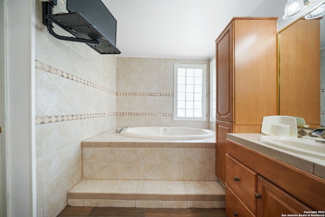 bathroom with vanity and a relaxing tiled tub