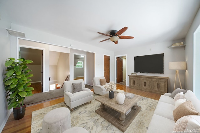 living room with light wood finished floors and a ceiling fan