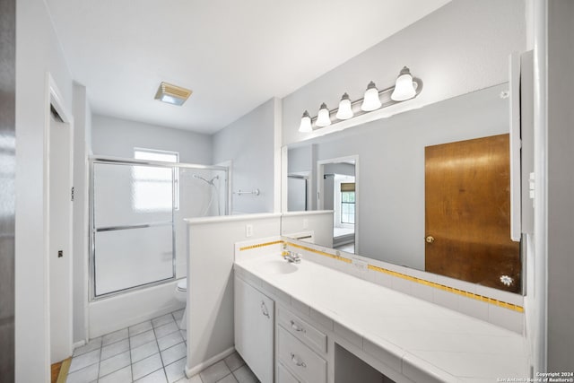 full bathroom with toilet, vanity, tile patterned floors, and enclosed tub / shower combo