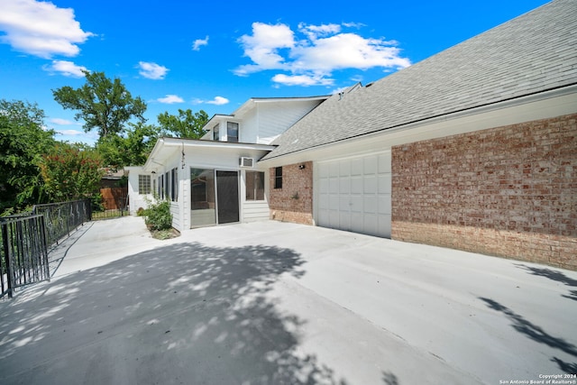 view of side of home featuring a sunroom and a garage