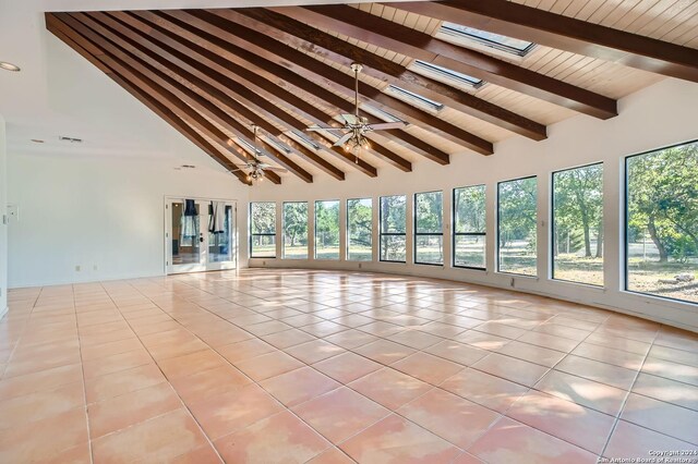 unfurnished room with light tile patterned floors, high vaulted ceiling, a skylight, and beamed ceiling