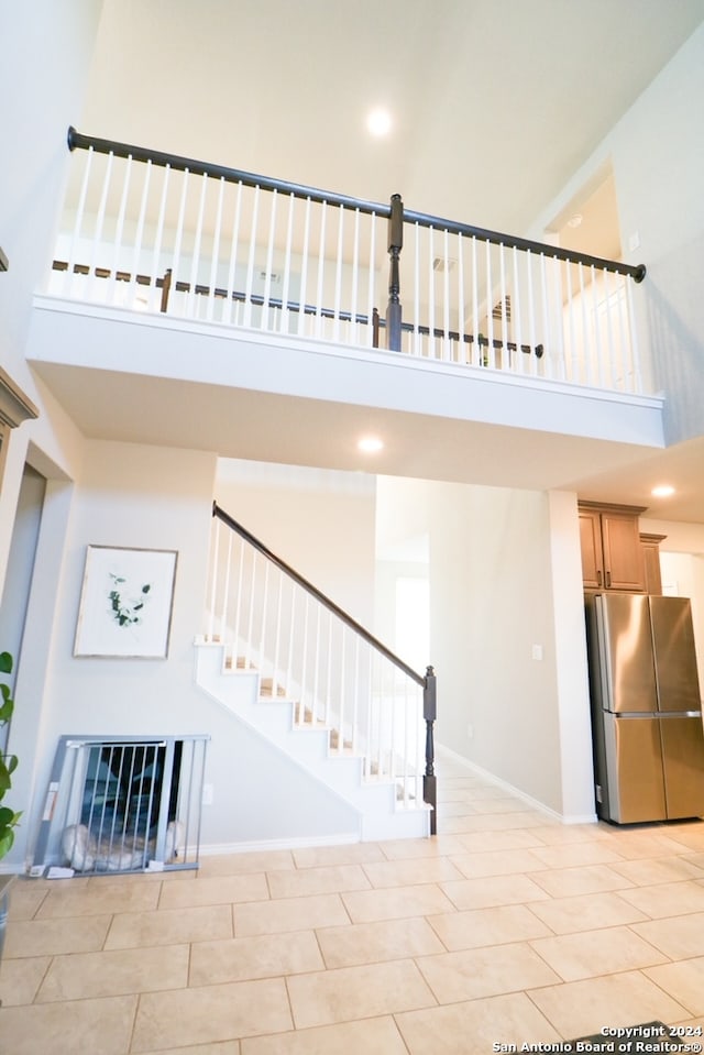 staircase with a high ceiling and tile patterned floors