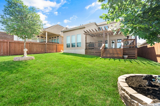 back of house featuring a deck, a pergola, and a lawn