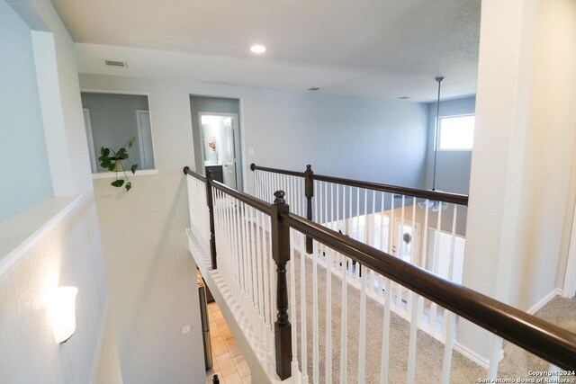 corridor featuring light colored carpet