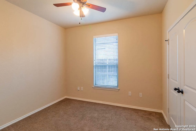 empty room featuring ceiling fan and carpet flooring