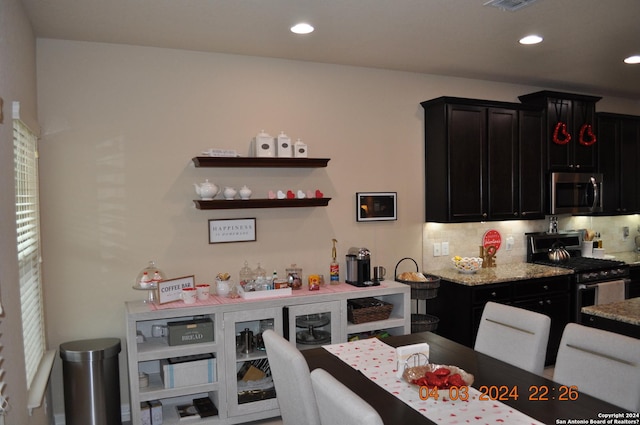 kitchen with stainless steel appliances, recessed lighting, dark cabinets, and decorative backsplash