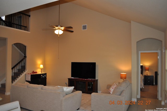 living area with stairs, high vaulted ceiling, visible vents, and a ceiling fan