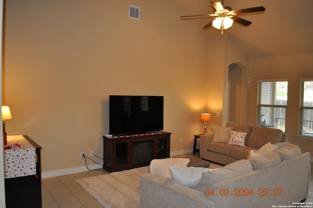 living room featuring light tile patterned floors, ceiling fan, arched walkways, visible vents, and baseboards