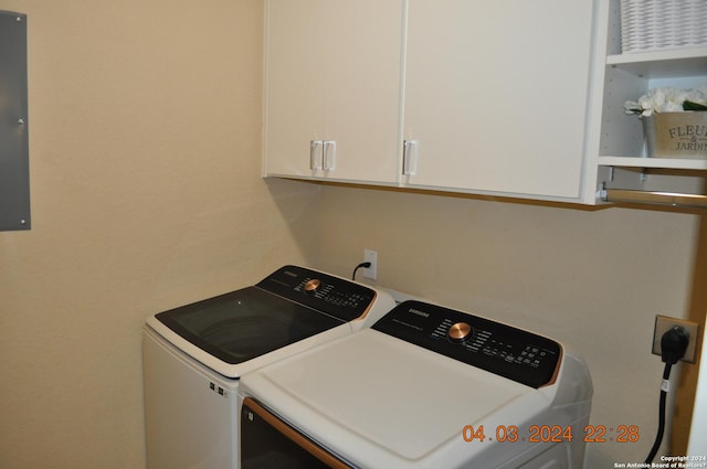 laundry area with separate washer and dryer and cabinet space