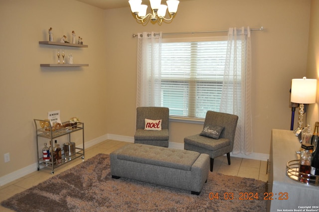 living area featuring a chandelier, light tile patterned flooring, and baseboards