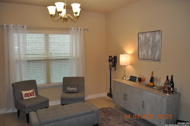 living area featuring light tile patterned flooring, baseboards, and an inviting chandelier