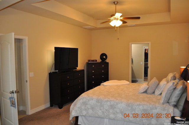 carpeted bedroom with a raised ceiling, visible vents, and baseboards