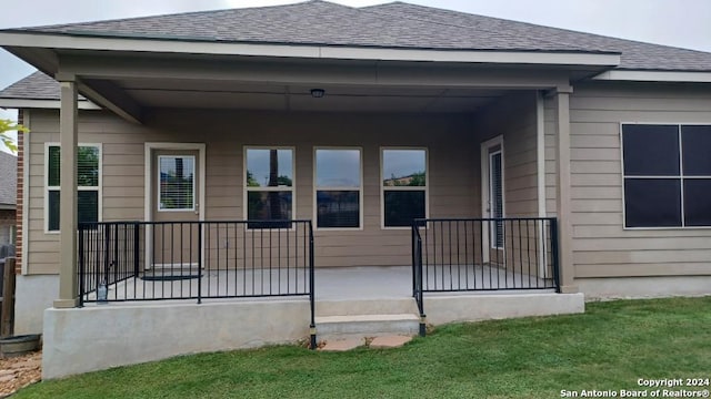 exterior space with a porch, a shingled roof, and a front lawn