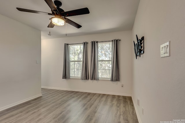 empty room with ceiling fan and light wood-type flooring