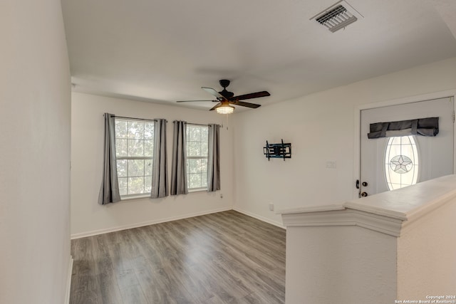 unfurnished living room featuring ceiling fan and hardwood / wood-style flooring