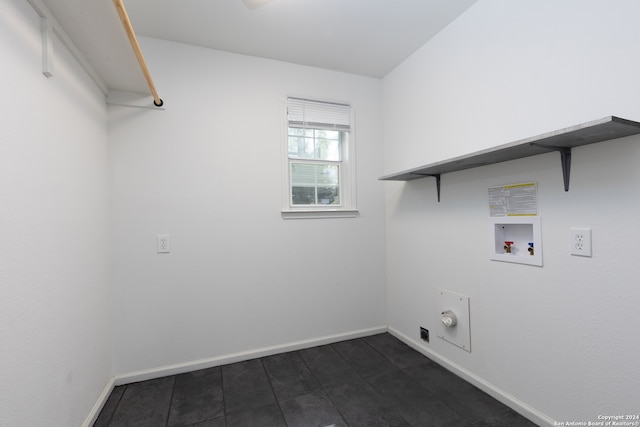 washroom featuring dark tile patterned flooring and hookup for a washing machine