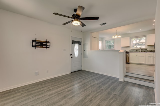 interior space with ceiling fan with notable chandelier, sink, and wood-type flooring